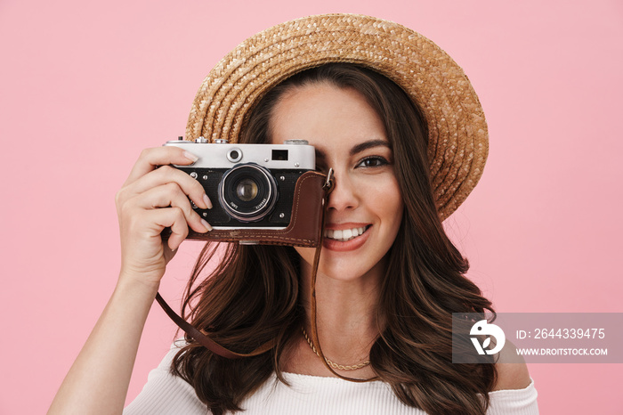 Image of joyful brunette woman taking photo on retro camera