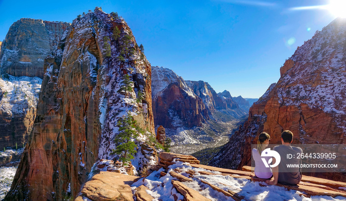 COPY SPACE: Young couple sits atop Angel’s Landing and observes the canyon