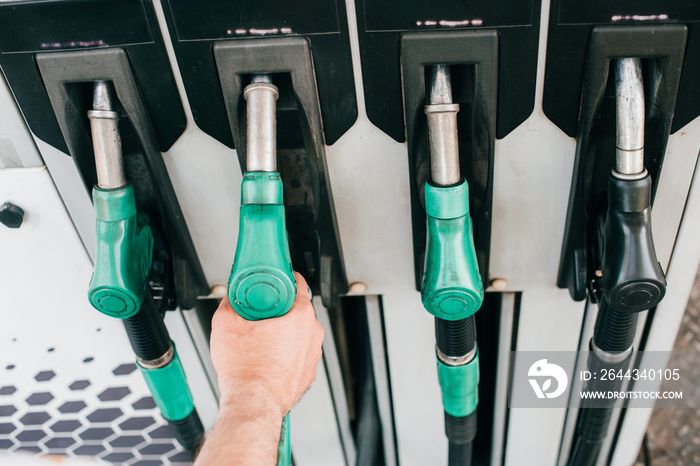 Cropped view of man holding fueling nozzle on car refueling station