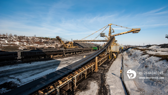 Delivery of Iron ore by a Conveyor Belt from a Warehouse and Loading into Railway Dump Cars.