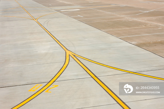 Airport yellow taxiway lines markings on the apron on concrete asphalt, sign for airplane pilots.