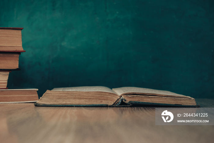 Beautiful vintage ancient books. Pattern background for design. The book on a wooden table and green wall background.