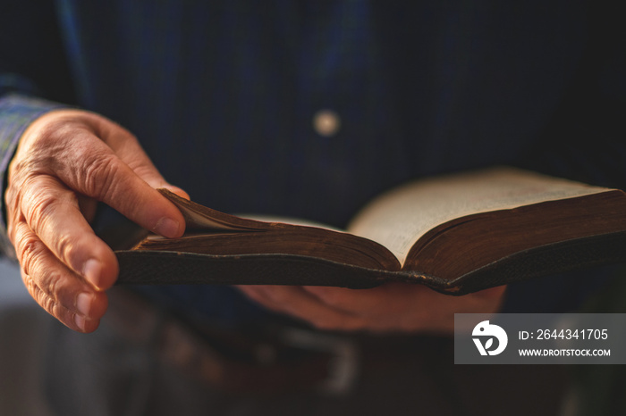 Old Bible in hands of an old man