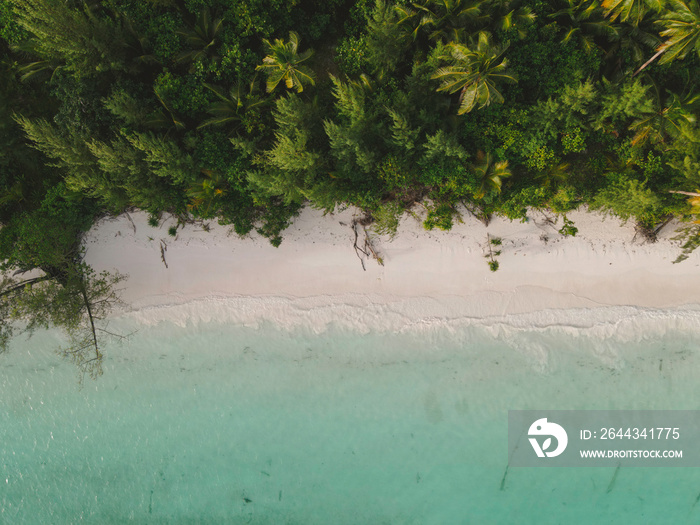 Aerial view of white sand turquoise beach with tropical jungle in Indonesia