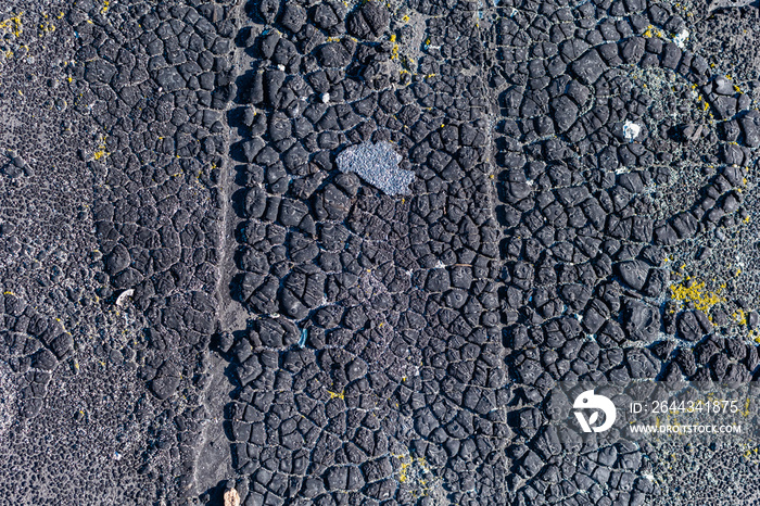 Old cracked black resin surface on roof of house for renovation