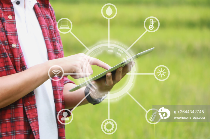 Smart farming, using modern technologies in agriculture. Man agronomist farmer with digital tablet computer in field using apps and internet of things(IOT) in production and agricultural research