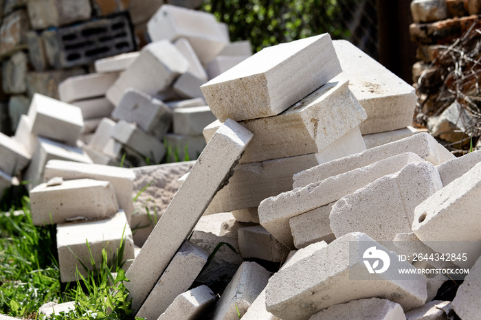 A pile of construction waste is in the yard. White brick or foam block