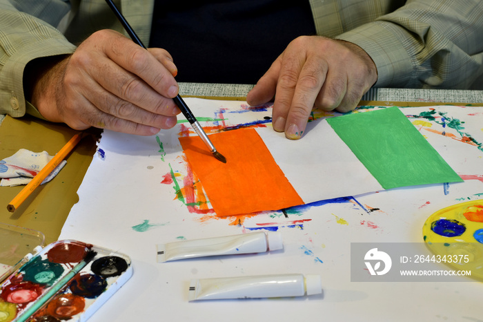 The artist paints the flag of Ireland.