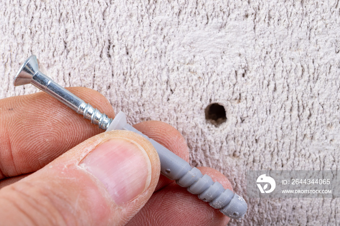 Hole in the wall, screw and dowel for fixing in concrete. Wall mounting methods.