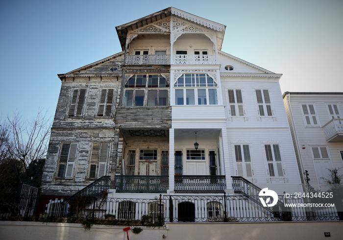 A historic semi-detached house on the Marmara island of Heybeliada near Istanbul. The right half of the house was maintained and painted white, the right is run down. Greek architecture in Turkey, woo