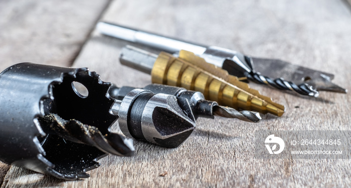 Variety of different types of bit drill displyed on old wooden background. Selective focus.