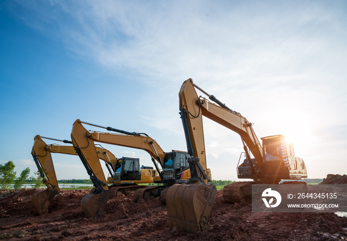 A large construction excavator of yellow color on construction site in quarry for quarrying. Industrial image. Excavator with Bucket lift up digging the soil in the construction site on sky background