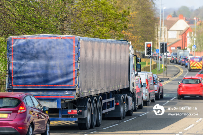 lorry truck stuck in busy traffic on road in british town at noon time