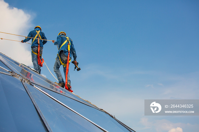 Male workers rope access height safety connecting with a knot safety harness, to ascending, construction site oil tank dome.