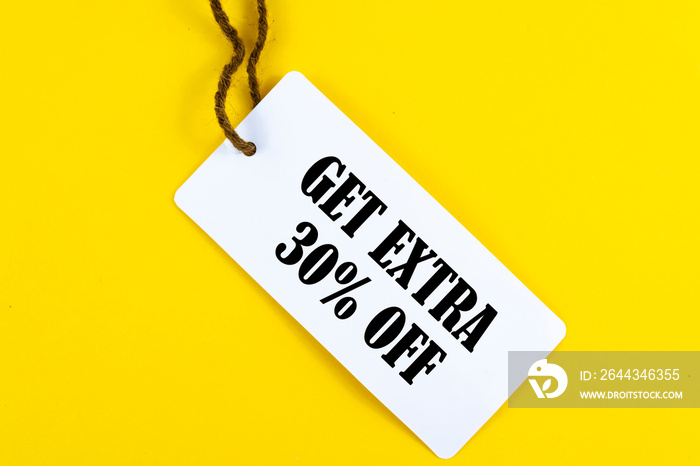 GET EXTRA 30 OFF percent text on a white tag on a yellow paper background