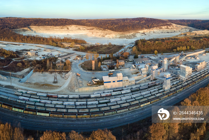 Aerial view of cargo train loaded with crushed stone materials at mining factory. Railway transportation of grinded limestone ore