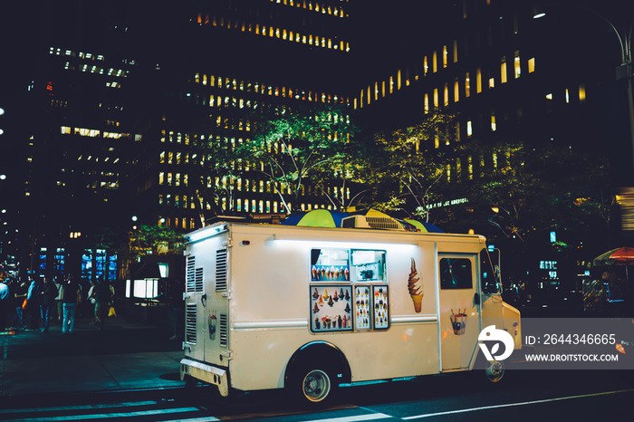 Van automobile with ice cream retail parked on street near building in downtown at evening, business startup with trading sweets via vehicle truck traveling in city distributing food during weekends