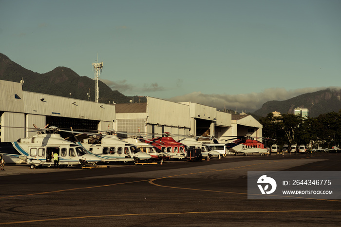 Hangar with helicopters at sunset.