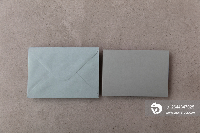 Blank grey card with grey paper envelope template mock up on a concrete background