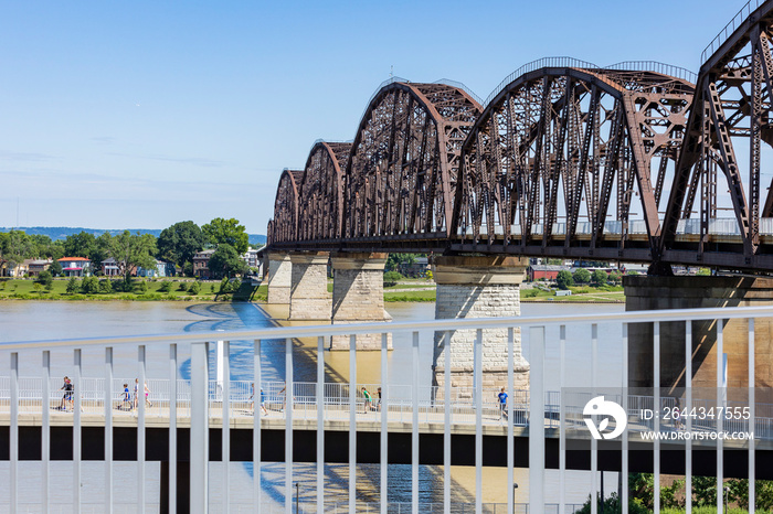 View of a pedestrian bridge over the Ohio River in Louisville, Kentucky from a ramp leading to the bridge.