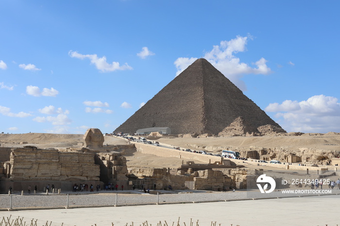 Pyramids of Giza. Scene with tourists near pyramid in Egyptian desert. Travel to the African continent for look of a UNESCO World Heritage Site.