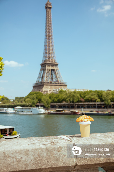 cup of coffee and croissant on the parapet against Eiffel tower