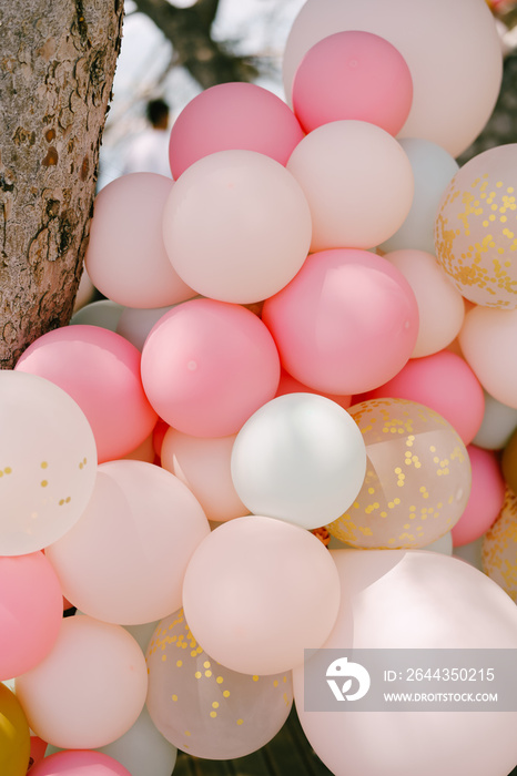 Close-up of many helium balloons in pastel colors.