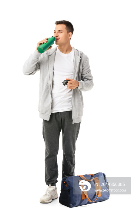 Sporty young man with bag and bottle of water on white background