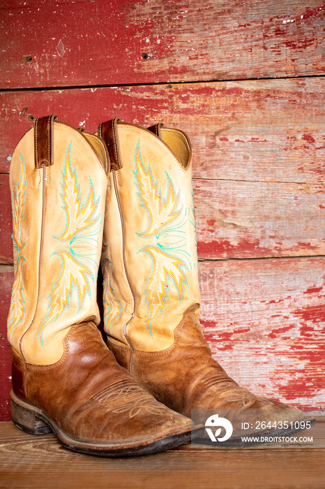 Cowboy boots on red barn board