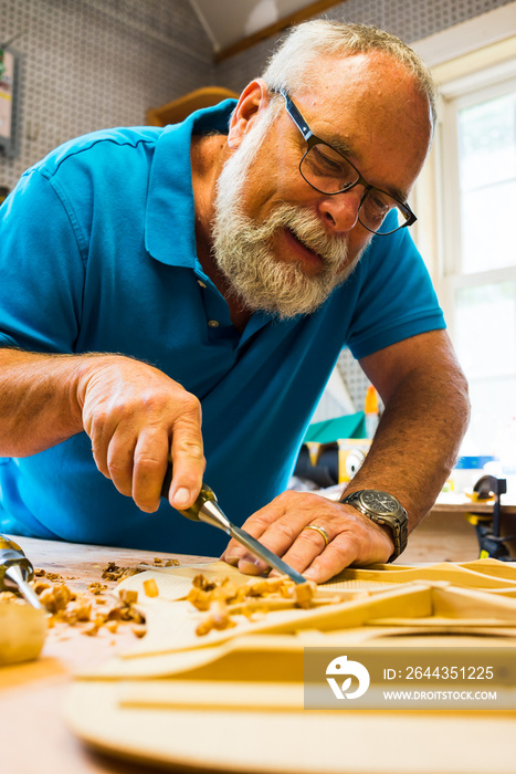 middle aged male woodworker, craftsman,building a guitar, luthier.