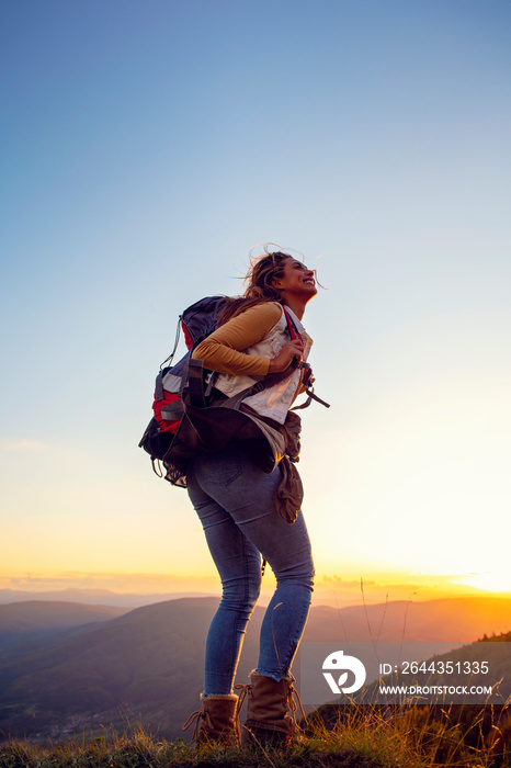 Portrait of happy young woman hiking in the mountains