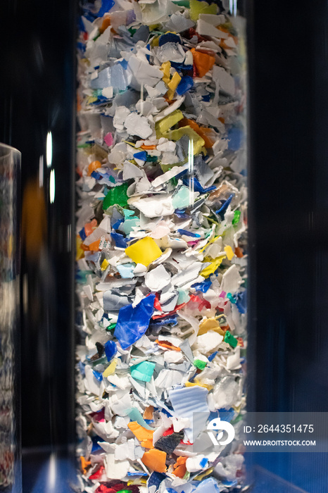 microplastic flakes in a cylinder to teach recycling of plastics. Environmental protection against plastics pollution from sea and rivers. colored flakes of shredded plastic. Plastic ocean in bottle