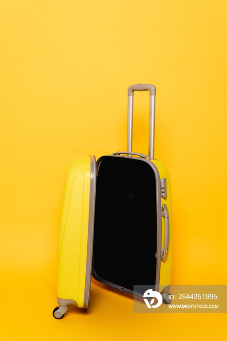 open empty travel bag on yellow background