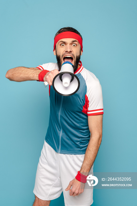 emotional stylish sportsman with loudspeaker on blue background