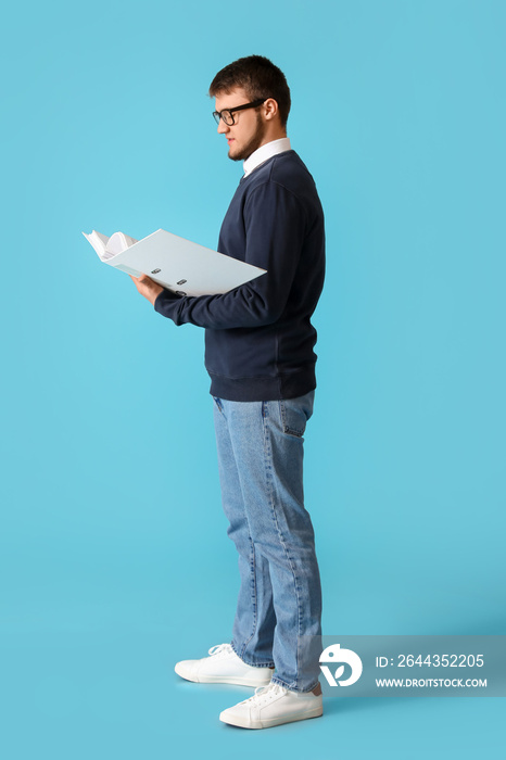 Young man with folder on color background