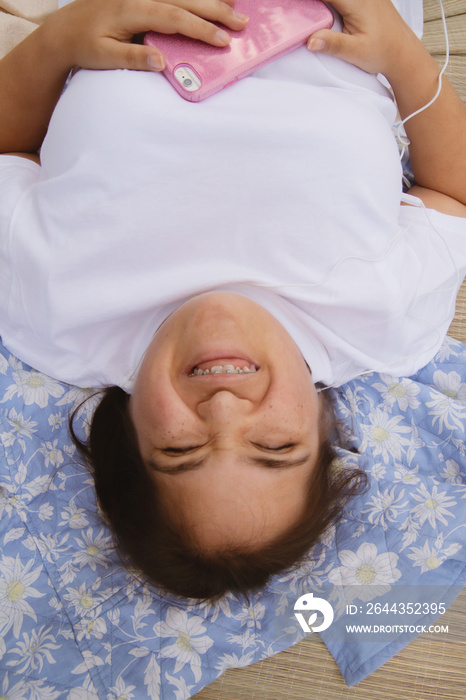 Curvy girl with Down syndrome listening to music in the park