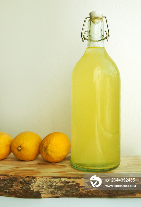 Homemade lemonade in an eco-friendly bottle, lemonade in reusable bottles. Lemons. Eco concept. Horizontal composition On a wooden kitchen board. Tree bark.