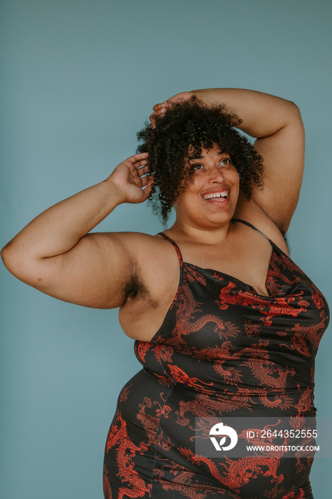 portrait of a plus size afro indigenous person hands in hair smiling