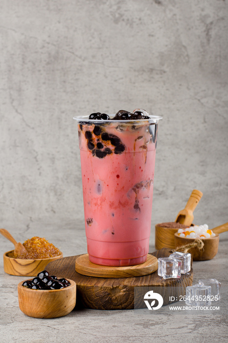 Boba or tapioca pearls is taiwan bubble milk tea in plastic cup with red velvet flavor on texture  background, summers refreshment.