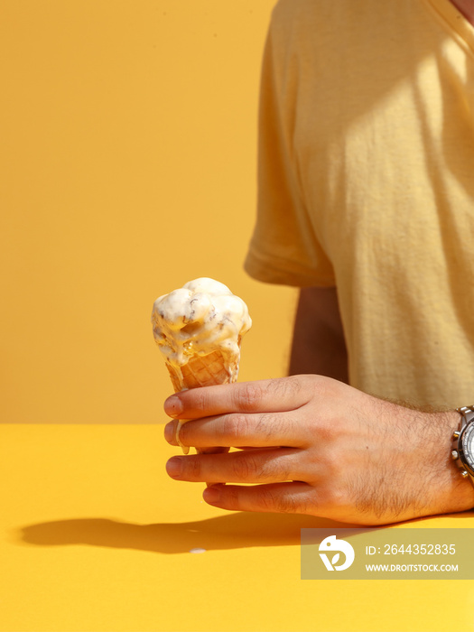 A man holds a waffle cup with a melting ice cream.