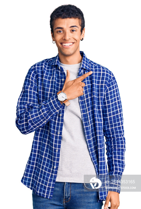 Young african amercian man wearing casual clothes cheerful with a smile on face pointing with hand and finger up to the side with happy and natural expression