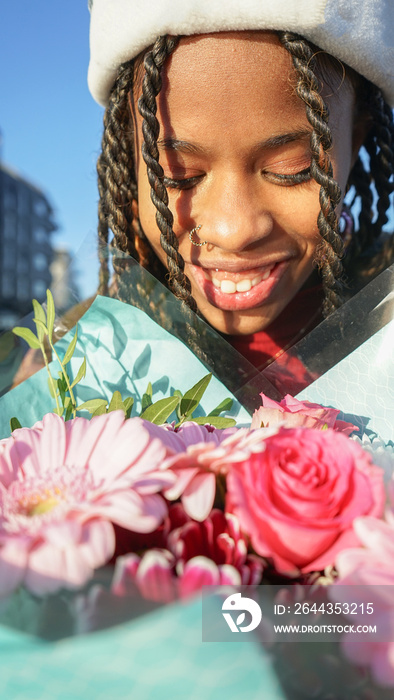 Close-up of smiling woman with bouquet outdoors