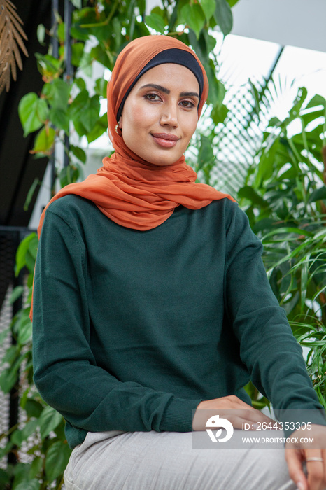 Portrait of smiling woman wearing headscarf at home