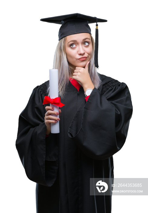 Young blonde woman wearing graduate uniform holding degree over isolated background serious face thinking about question, very confused idea