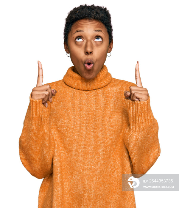 Young african american woman wearing casual clothes amazed and surprised looking up and pointing with fingers and raised arms.