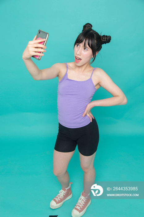 Studio shot of girl taking selfie