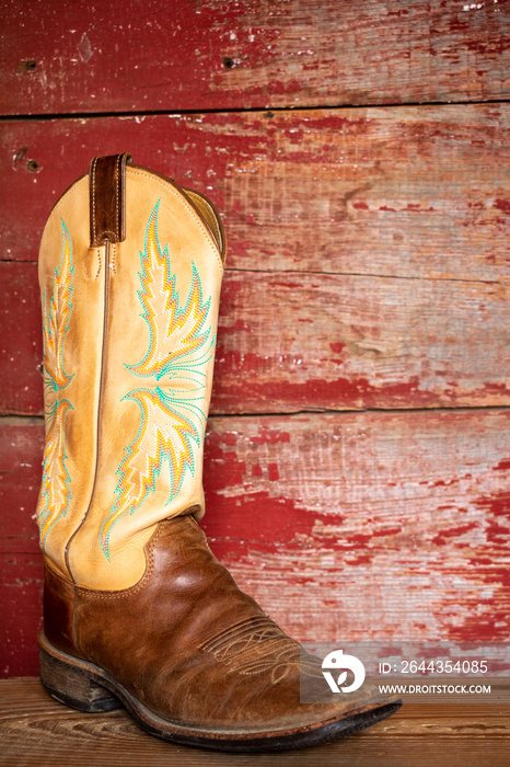 Cowboy boots on red barn board