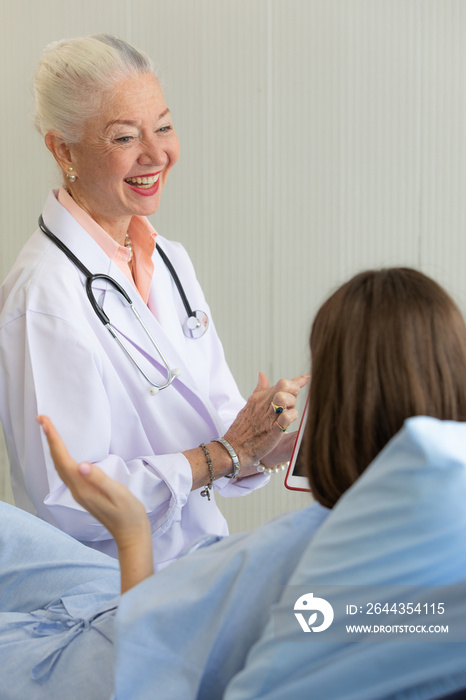 Senior older female doctor visit the patient room and make a history taking for diagnosis and cure process