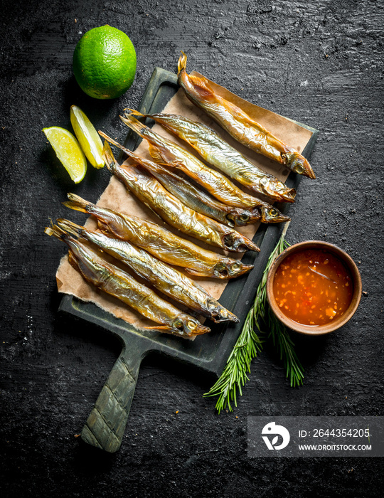 Smoked fish with lime, rosemary and sauce in bowl.