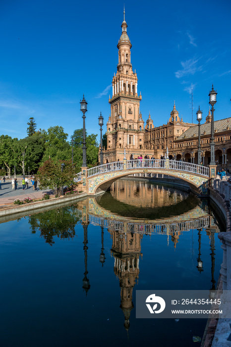 The beautiful Plaza de Espana (translates to Spanish Square) in Seville, with the ornately decorated towers reflecting in water